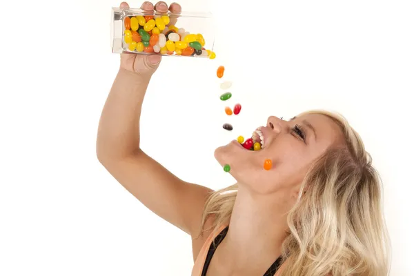 Woman pouring jelly beans mouth — Stock Photo, Image
