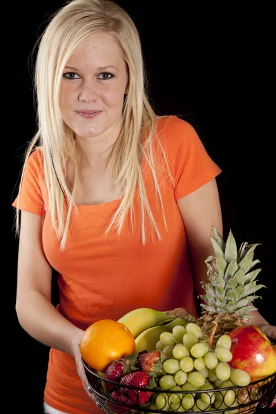 Žena v oranžové s ovocem — Stock fotografie