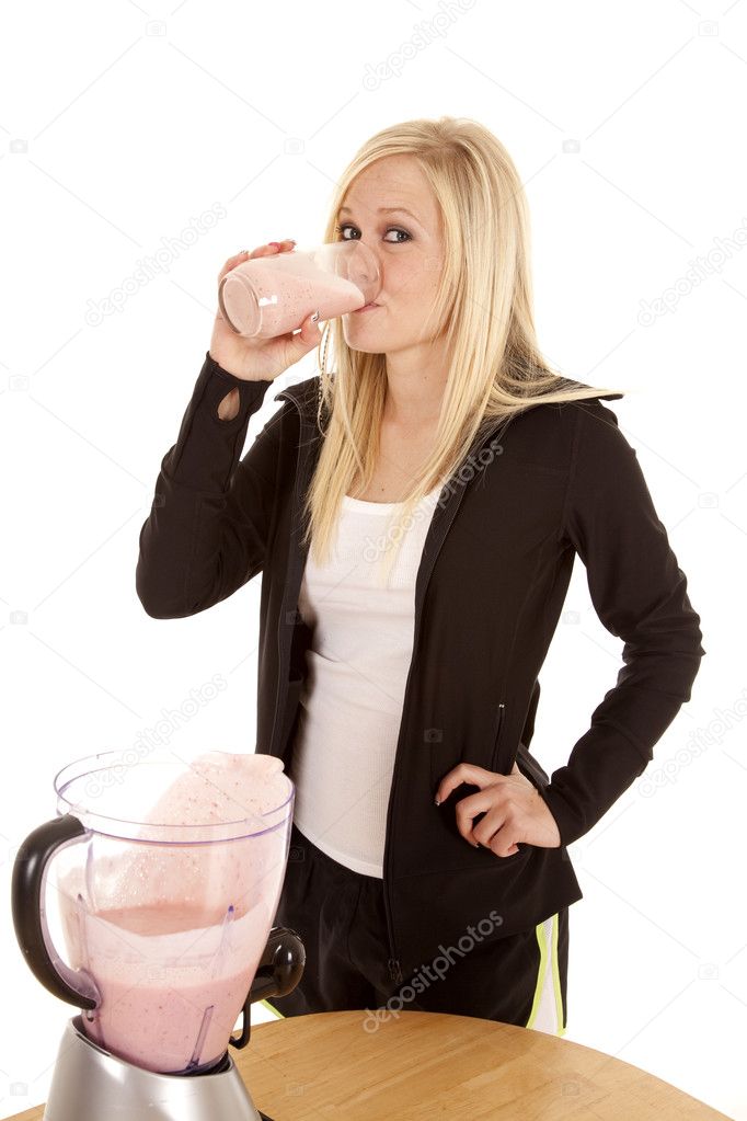 Woman drinking smoothie by table
