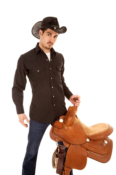 Cowboy allvarliga med sadel — Stockfoto