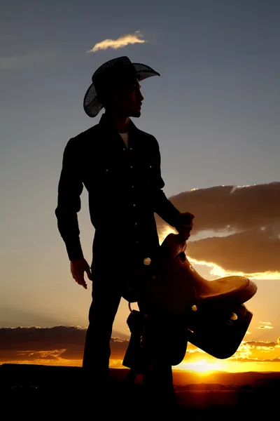 Cowboy silhouette with saddle — Stock Photo, Image