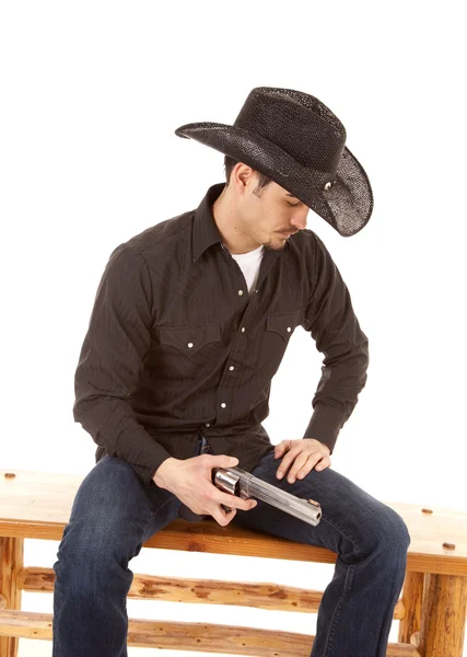 Kovboj sedí drží zbraň — Stock fotografie