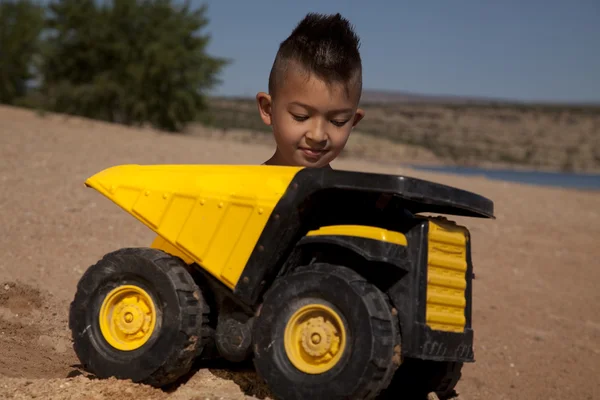 Boy behind truck in sand — Stock Photo, Image