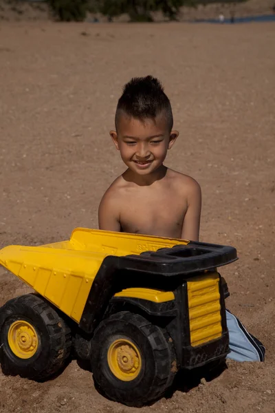 Pojke med lastbil i sand — Stockfoto