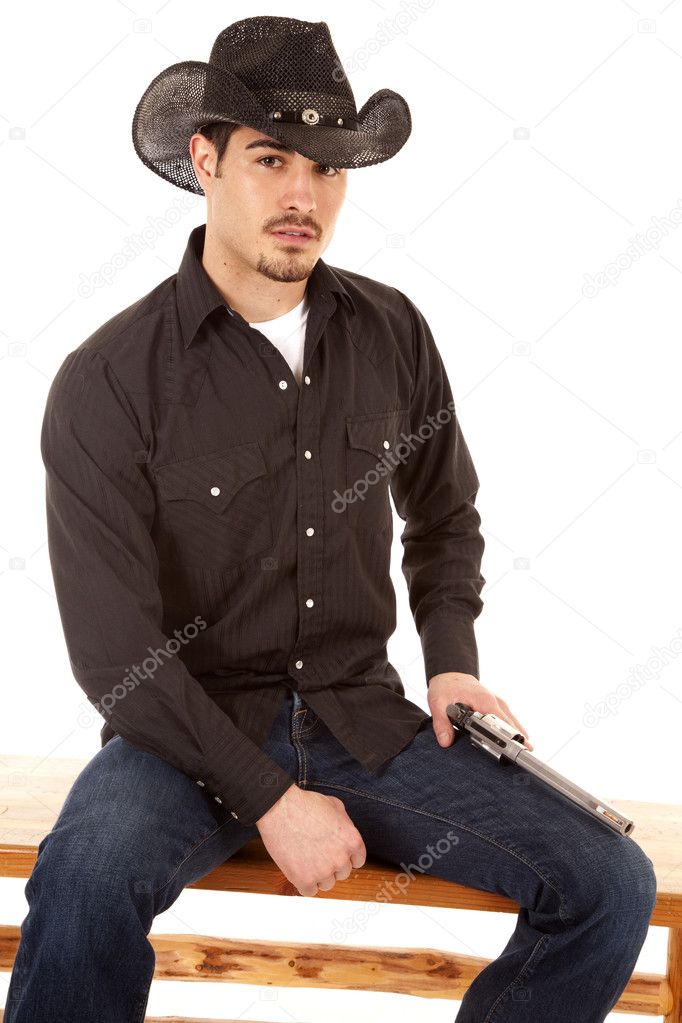 Cowboy sitting with gun on leg