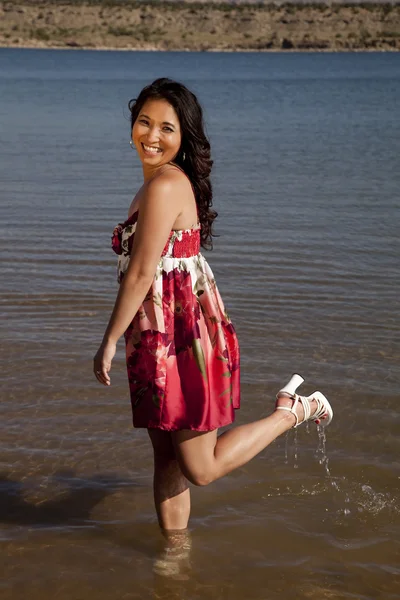 Женщина красное платье ноги вверх по воде — стоковое фото