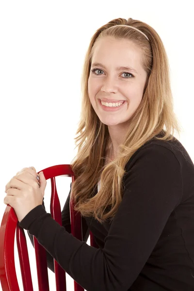 Menina vermelho cadeira sorriso — Fotografia de Stock