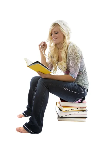 Mädchen liest auf Bücherstapel. — Stockfoto