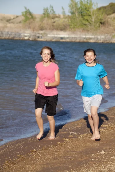 Девушки бегут по пляжу — стоковое фото
