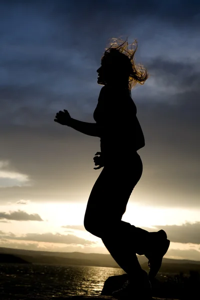Silueta de una mujer corriendo — Foto de Stock