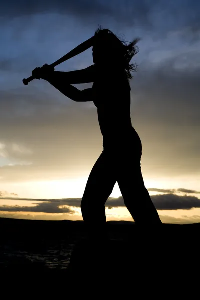 Silhouette d'une femme balançant une batte — Photo