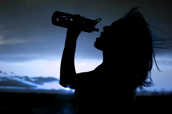 水のボトルを持つ女性のシルエットをクローズ アップ — ストック写真