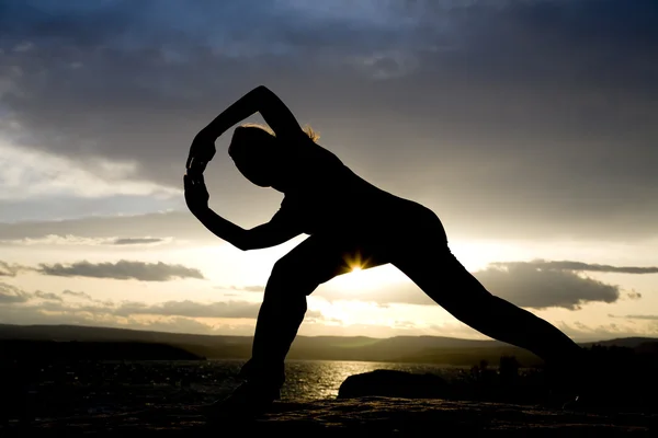 Silhouette of woman doing yoga — Stock Photo, Image