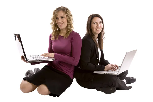 Two women backs together on computers — Stock Photo, Image