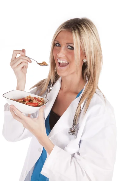 Woman doctor bite of cereal — Stockfoto