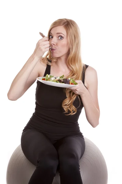 Frau isst Salat in Schwarz. — Stockfoto