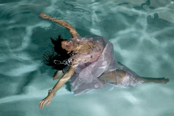 stock image Woman floating under water arms out