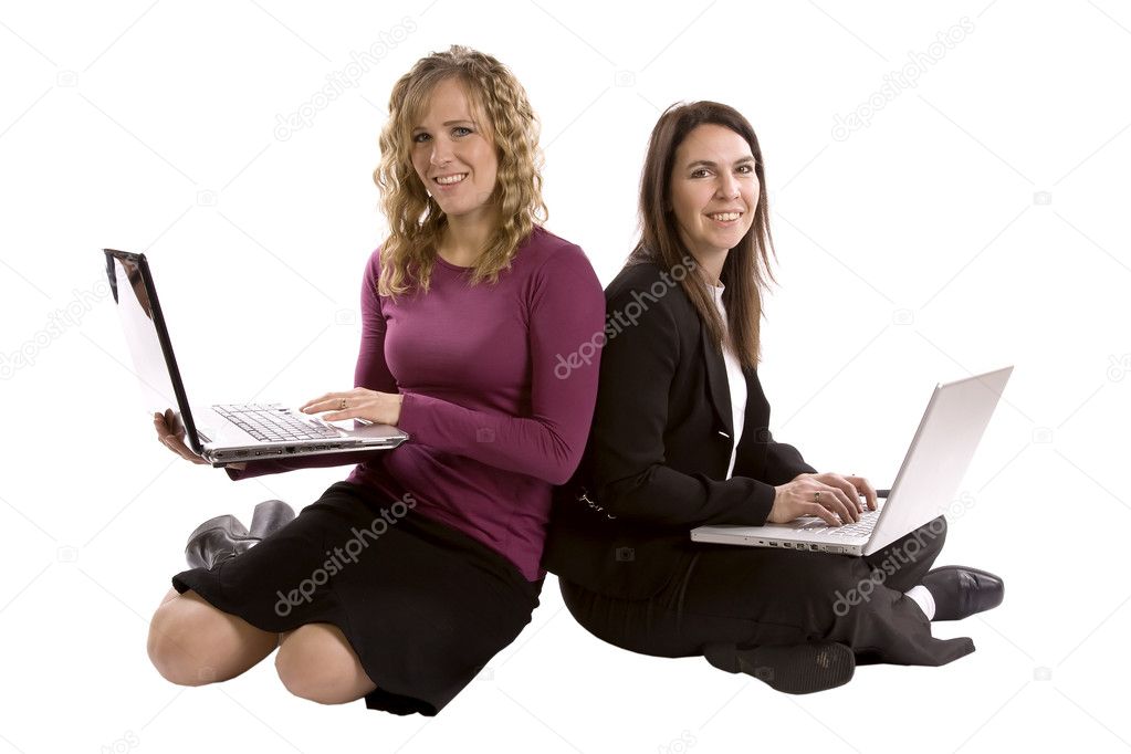 Two women backs together on computers