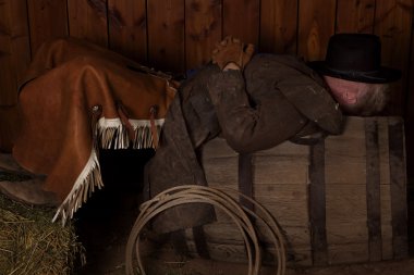 Cowboy laying on barrel clipart