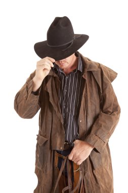 Cowboy with duster holding hat clipart
