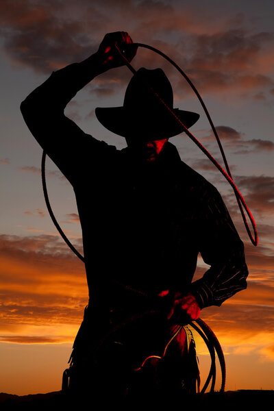 Cowboy in sunset with rope