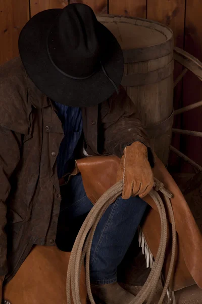 Cowboy kneeling by barrel head down close — Stock Photo, Image