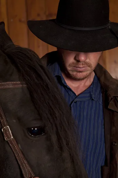 Cowboy tittar ner av hästhuvud — Stockfoto