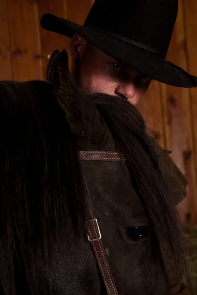 Cowboy looking over horse head — Stock Photo, Image