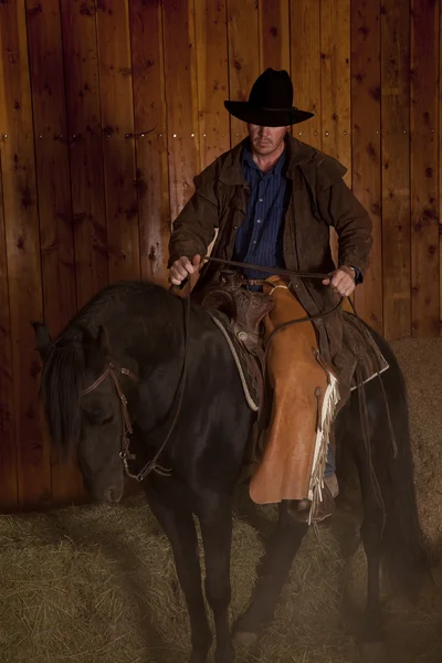 Cowboy riding horse black — Stock Photo, Image