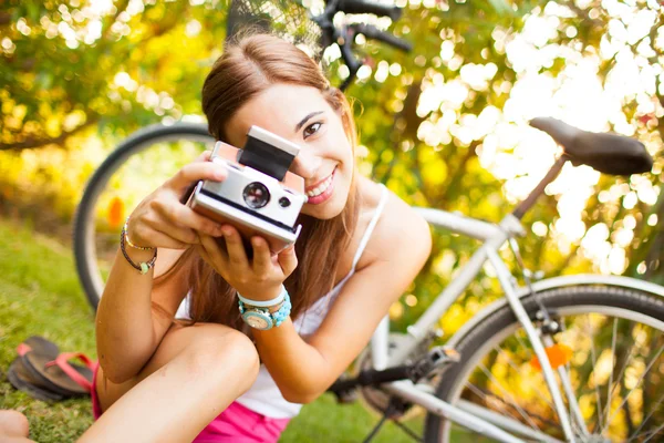 Schöne junge Frau spielt mit einer Vintage-Kamera — Stockfoto