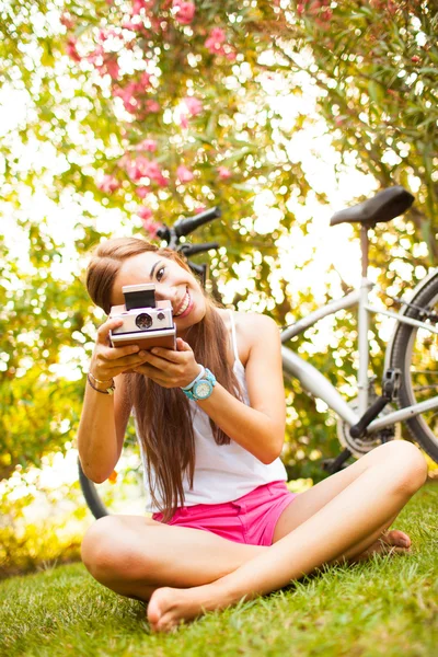 Vacker ung kvinna leker med en vintage kamera — Stockfoto