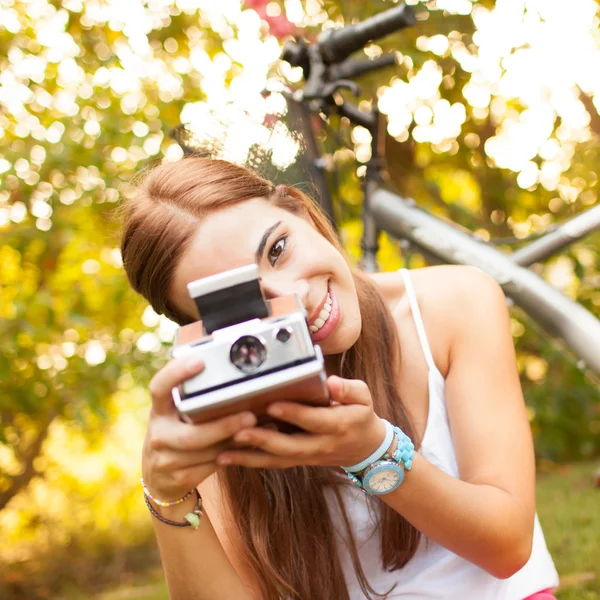 Όμορφη νεαρή γυναίκα που παίζει με ένα εκλεκτής ποιότητας φωτογραφική μηχανή — Φωτογραφία Αρχείου