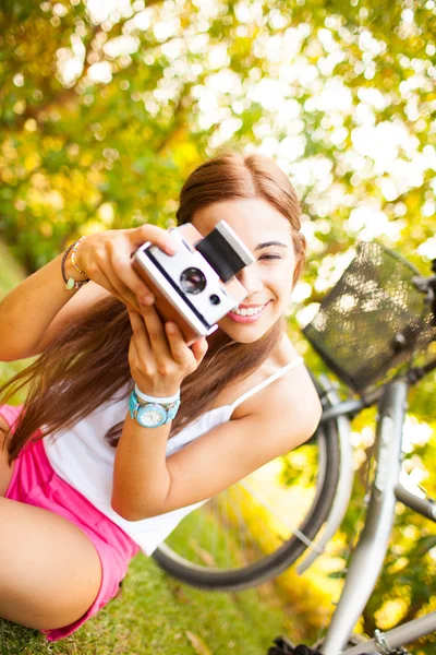 Όμορφη νεαρή γυναίκα που παίζει με ένα εκλεκτής ποιότητας φωτογραφική μηχανή — Φωτογραφία Αρχείου