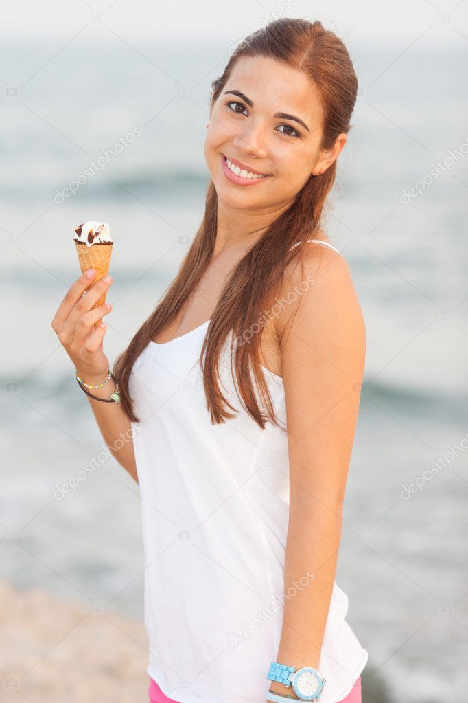 Portrait of a young beautiful woman eating ice-cream cone