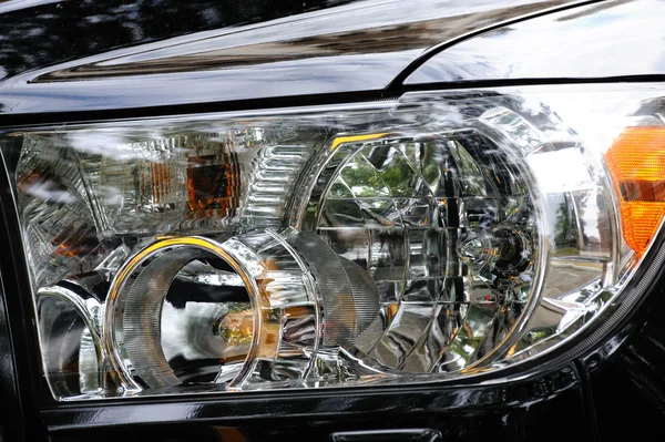 Black modern automobile headlight as background — Stock Photo, Image