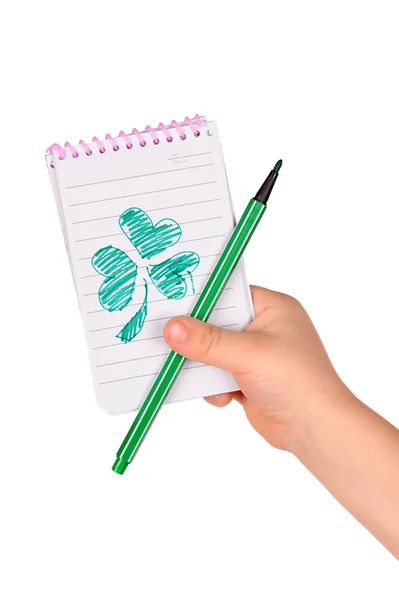 As mãos das crianças seguram caderno com um trevo pintado — Fotografia de Stock