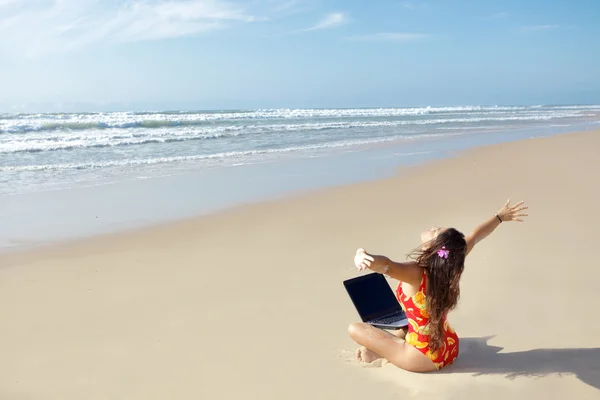 Kvinna med datorn på stranden — Stockfoto