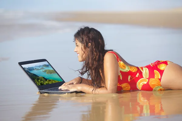 Mujer usando laptop en la playa — Stok fotoğraf