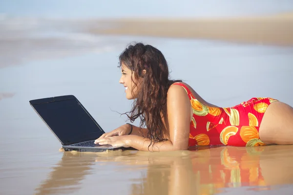 Frau benutzt Laptop am Strand — Stockfoto