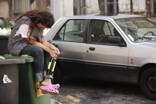 Mulher bêbada sentada no lixo — Fotografia de Stock