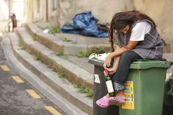 Triest dronken dakloze vrouw op bin — Stockfoto