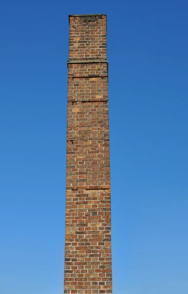 古いひびの入ったレンガ煙突 - 青空の背景 — ストック写真