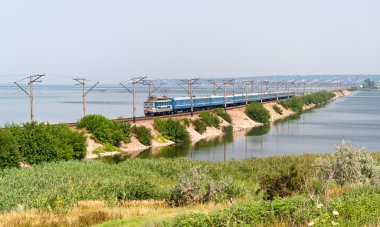 Passenger electric train on a dam clipart