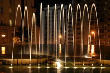 Beautiful lit fountain at night clipart