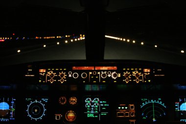 Aircraft landing at night with runway ahead