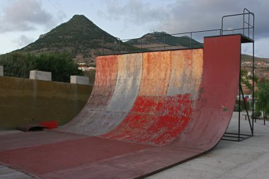 Deteriorated skate half pipe at sunset clipart