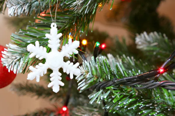 Christmas snow flake on a christmas tree — Stock Photo, Image