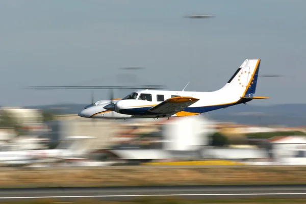 Small aircraft fly by at an airport — Stock Photo, Image