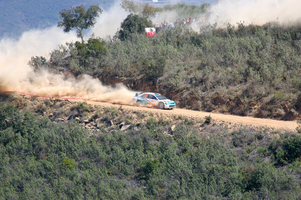 Rally car passing on a dirt track