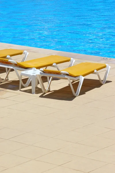 Pool restbeds and blue water — Stock Photo, Image